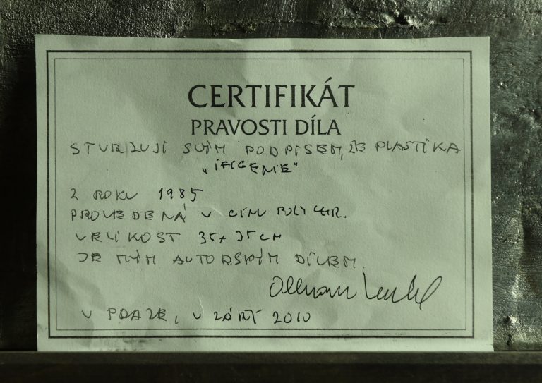 Velký polychromovaný cínový reliéf Ifigenie vytvořil Olbram Zoubek v dubnu roku 1985. Vznikl jako výřez z původního cementového reliéfu stejného jména, který měl rozměr  62 x 62 cm.