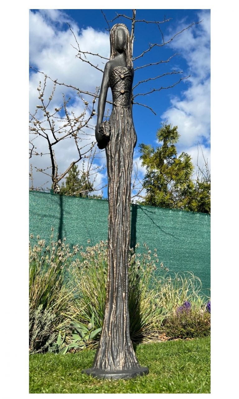 Sochu Dáma s kabelkou v knoflíkových šatech tvoří velmi štíhlá, 105 cm vysoká postava ženy, jejíž šat tvoří zároveň podstavec sochy.